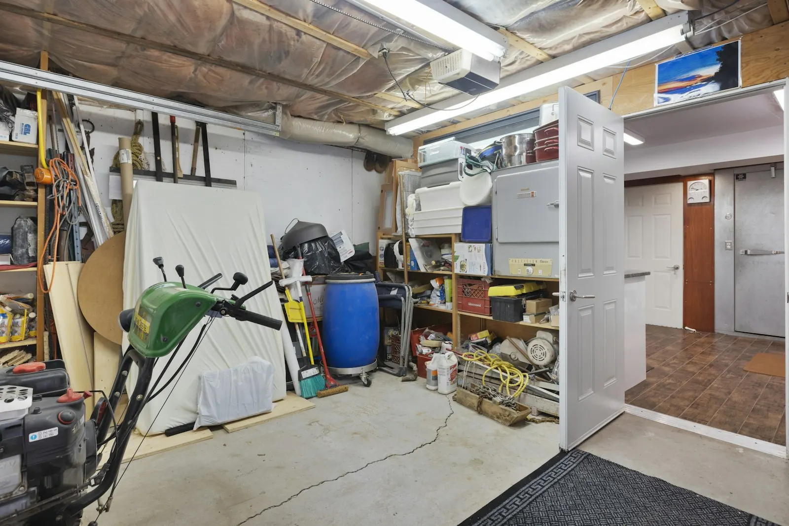 Symbolbild: vollgestellte Garage mit Regalen, Kisten und Werkzeug vor der Räumung